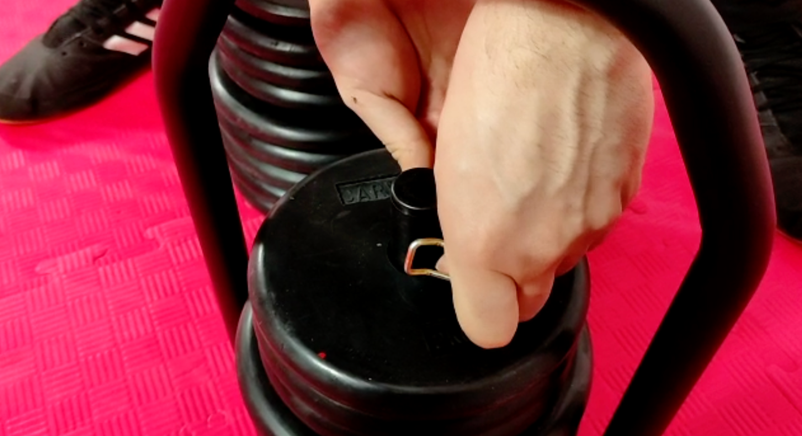 Hand operating the Regulabell locking mechanism to change weight plates